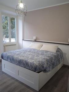 a white bedroom with a bed with a blue comforter at SOTTO LA ROCCA in Finale Ligure