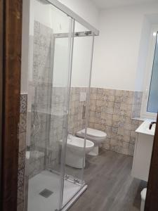 a bathroom with a toilet and a glass shower stall at SOTTO LA ROCCA in Finale Ligure