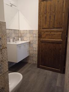 a bathroom with a sink and a wooden door at SOTTO LA ROCCA in Finale Ligure