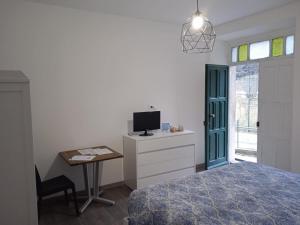 a bedroom with a bed and a desk with a tv at SOTTO LA ROCCA in Finale Ligure