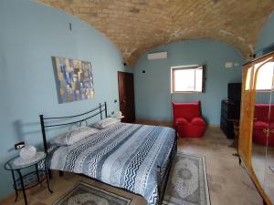 1 dormitorio con 1 cama y 1 silla roja en Casa Laura, en Corfinio