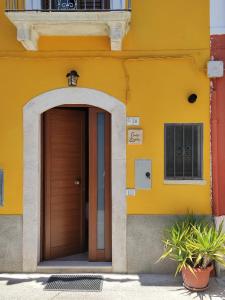 een geel gebouw met een houten deur voor de deur bij Casa Laura in Corfinio