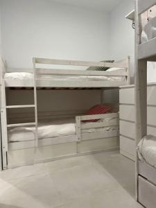 a white bunk room with three bunk beds at Villa Zeus in Rota