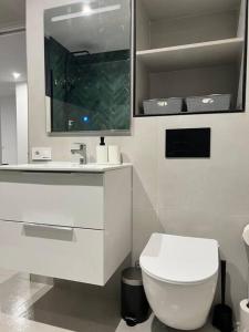 a bathroom with a white toilet and a sink at Villa Zeus in Rota
