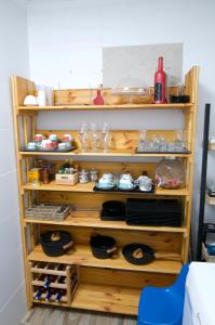una estantería de madera con platos y otros artículos. en Lux Valentia Olta Calpe, en Calpe