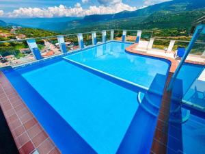 a large swimming pool with a view of a mountain at Trip Monkey Apartments in San Gil