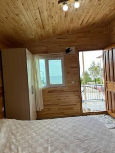 a bedroom with a bed and a large window at Silahcılar apart pansiyon in Kumluca