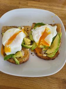 un plato blanco con dos huevos encima de la tostada en Langhouse Castle Bed and Breakfast, en Inverkip