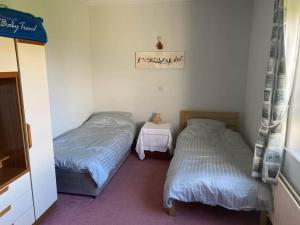 a bedroom with two beds and a table at Ballyliffin bungalow with stunning beach views in Ballyliffin