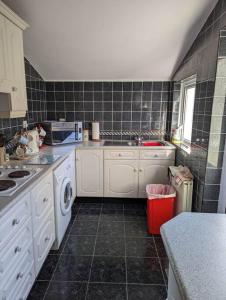 een keuken met een wastafel en een wasmachine bij Ballyliffin bungalow with stunning beach views in Ballyliffin