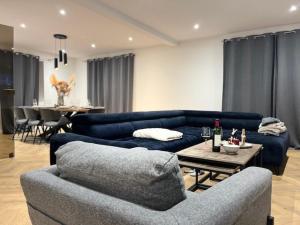 ein Wohnzimmer mit 2 blauen Sofas und einem Tisch in der Unterkunft Cosy Rent Villa Piscine Proche Strasbourg in Lampertheim