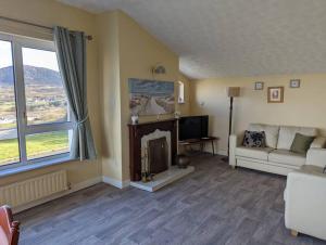 a living room with a couch and a fireplace at Ballyliffin bungalow with stunning beach views in Ballyliffin