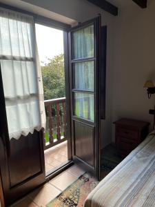 a bedroom with a door leading to a balcony at Posada San Tirso in Toñanes