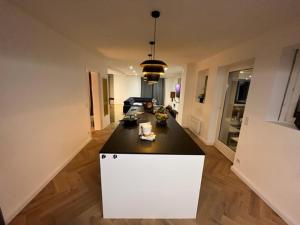 una cocina con una isla blanca en una habitación en Cosy Rent Villa Piscine Proche Strasbourg en Lampertheim