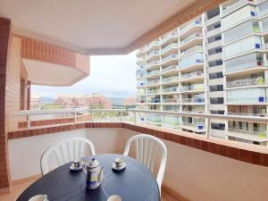einen Balkon mit einem Tisch und Stühlen sowie einige Gebäude in der Unterkunft Ayf 1ª linea de playa , costa marina dor in Oropesa del Mar