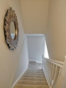 a stairway with a mirror on the wall at Chandra House in Swindon