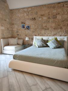 a bedroom with a large bed and a stone wall at Casa vacanze Modica Charme in Modica