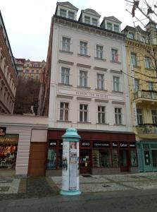 a large white building with a sign in front of it at Delux Kolonada in Karlovy Vary