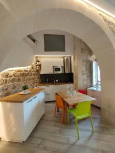 a kitchen with a table and chairs in a room at Casa vacanze Modica Charme in Modica