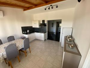 eine Küche und ein Esszimmer mit einem Tisch und einem Kühlschrank in der Unterkunft Haus Manda - Wohnung 7 in Ražanac