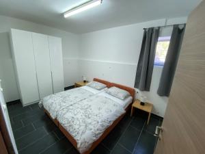 ein kleines Schlafzimmer mit einem Bett und einem Fenster in der Unterkunft Haus Manda - Wohnung 7 in Ražanac