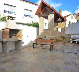 patio z ławką i piecem ceglanym w obiekcie A casiña do piorno w mieście Isla de Arosa