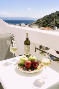 a plate of apples and a bottle of wine on a table at Lefka Ori - Agia Galini in Agia Galini