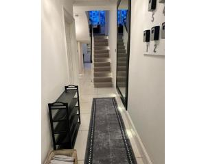 a hallway with stairs and a rug in a house at Victoria Square in London