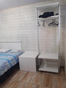 um quarto com uma cama e um beliche com uma prateleira em TownhouseFloripa II Praia do Moçambique-RioVermelho em Florianópolis