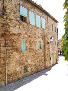 un antiguo edificio de piedra con ventanas en una calle en Casa Peratallada, en Peratallada