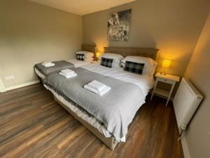 a bedroom with a large bed with two pillows at Lydney House Swaffham Sleeps 22 in Swaffham