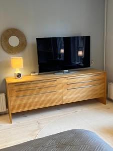 a large entertainment center with a large flat screen tv at Apothekergaarden Stege stuen mod gårdhaven in Stege