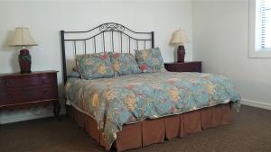 uma cama num quarto com 2 mesas de cabeceira e 2 candeeiros em Dogwood Springs Lodgings em Mineola