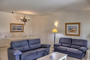 una sala de estar con 2 sofás azules y una mesa. en Villa V2 Duplex - Vilamoura Tennis, en Quarteira