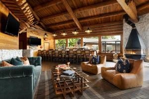 a living room with couches and a bar at Salmon Falls Resort in Ketchikan