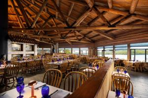 una sala da pranzo con tavoli, sedie e soffitti in legno di Salmon Falls Resort a Ketchikan