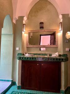 a bathroom with a vanity and a mirror at Riad Sassa Finda in Marrakesh