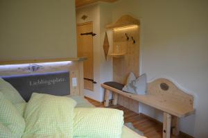 a bedroom with a bed and a bench and a table at "Hochegg" in Faistenau