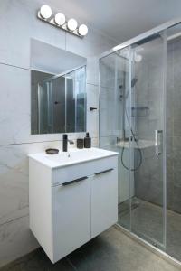 a white bathroom with a sink and a shower at Urban Condo 12 - 2 Bdr in Nicosia