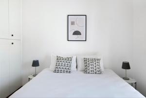 um quarto branco com uma cama branca com almofadas em Urban Condo 12 - 2 Bdr em Nicósia