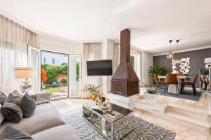 a living room with a couch and a fireplace at Cozy Townhouse Selwo in Estepona