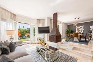 salon z kanapą i kominkiem w obiekcie Cozy Townhouse Selwo w mieście Estepona