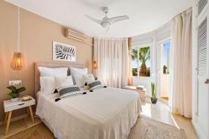 sypialnia z dużym białym łóżkiem i oknem w obiekcie Cozy Townhouse Selwo w mieście Estepona