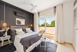sypialnia z dużym łóżkiem i balkonem w obiekcie Cozy Townhouse Selwo w mieście Estepona +33 zdjęcia