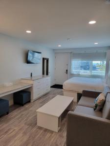1 dormitorio con cama, sofá y TV en Silver Surf Gulf Beach Resort, en Bradenton Beach
