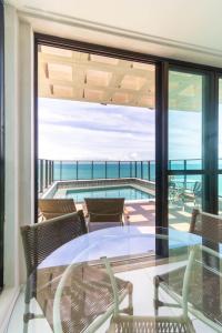a dining room with a view of the ocean at Beira-Mar Boa Viagem - Ivone Asfora by Bnb Flex in Recife