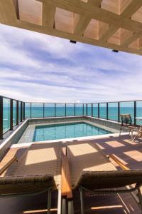 Una piscina en la parte superior de un edificio con vista al mar. en Beira-Mar Boa Viagem - Ivone Asfora by Bnb Flex, en Recife