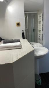 La salle de bains blanche est pourvue d'un lavabo et d'un miroir. dans l'établissement Marais joli deux pièces, à Paris