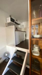 - une petite cuisine avec des placards blancs et un four micro-ondes dans l'établissement Marais joli deux pièces, à Paris