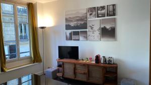 salon z telewizorem w drewnianym centrum rozrywki w obiekcie Marais joli deux pièces w Paryżu